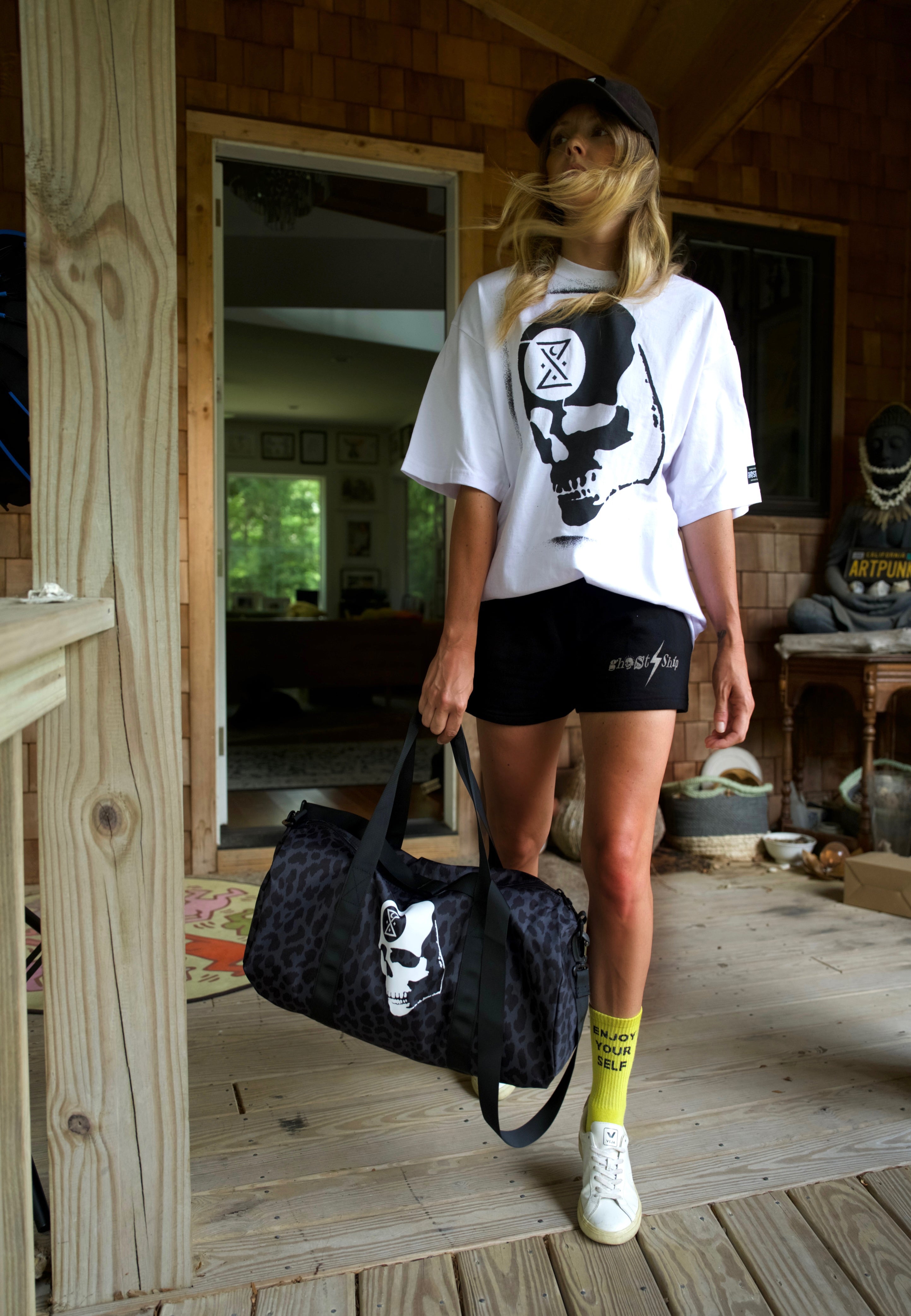 model jacq winter, writer jacq winter, a woman with luggage, woman in a white and black skull shirt