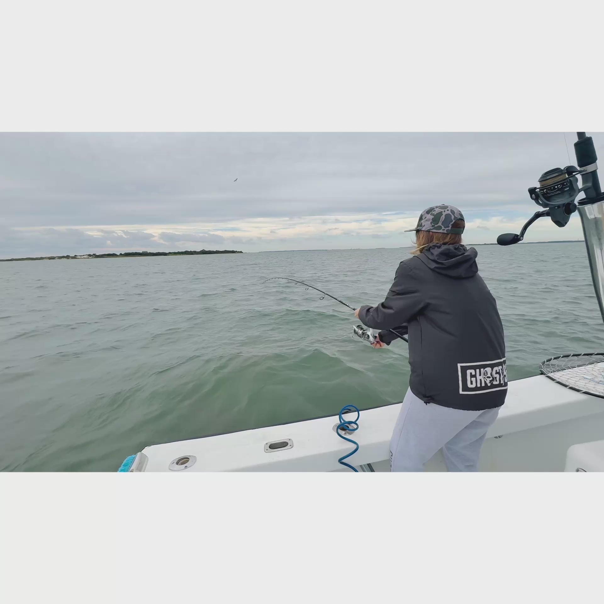 video of a woman reeling a large fish onto a boat