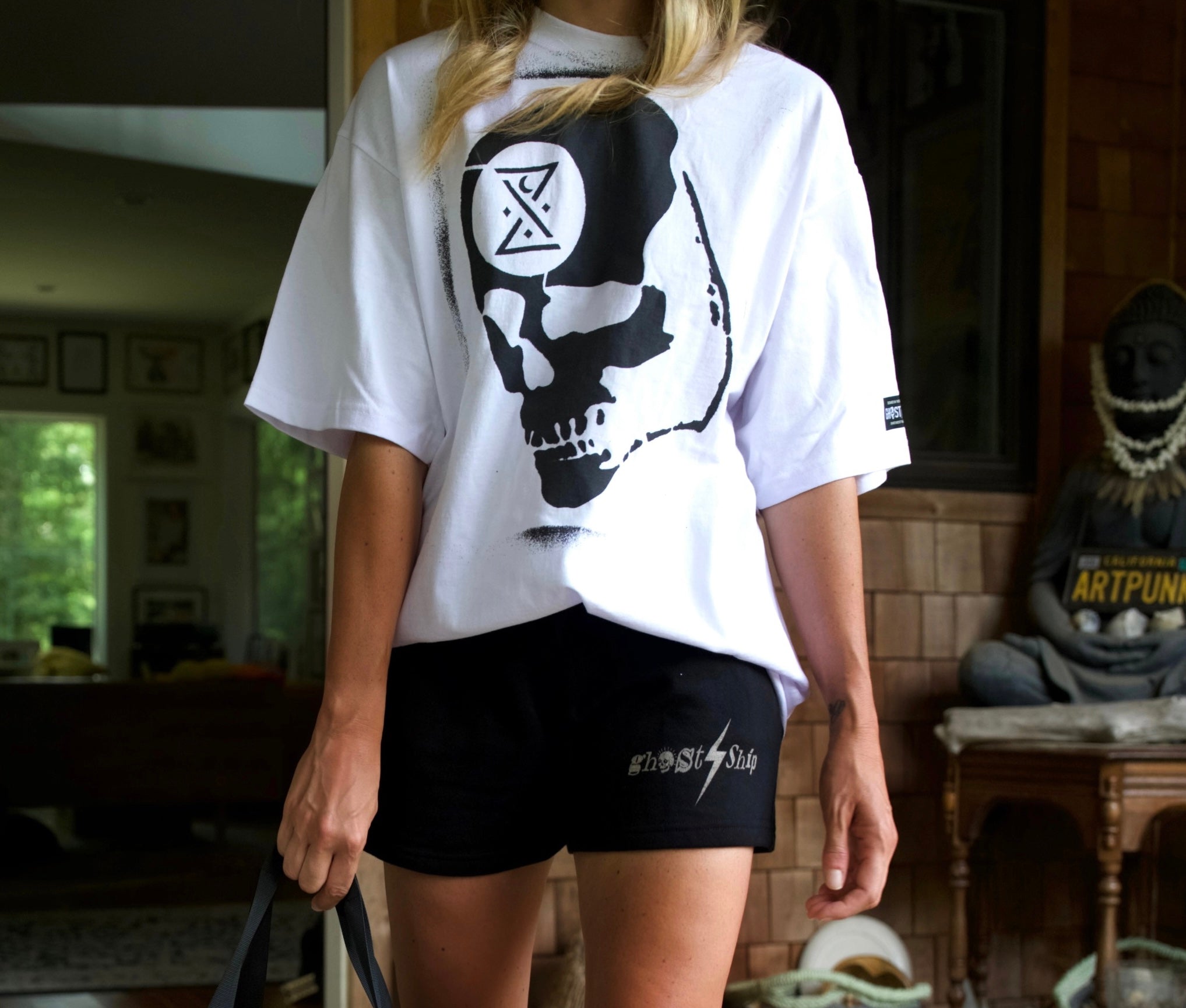 white t-shirt with ghost ship ominous skull graphic and black sweat shorts with lightning bolt